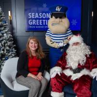 Woman smiles next to Santa and Louie